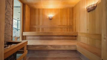 A sauna with wooden benches and a stone wall.