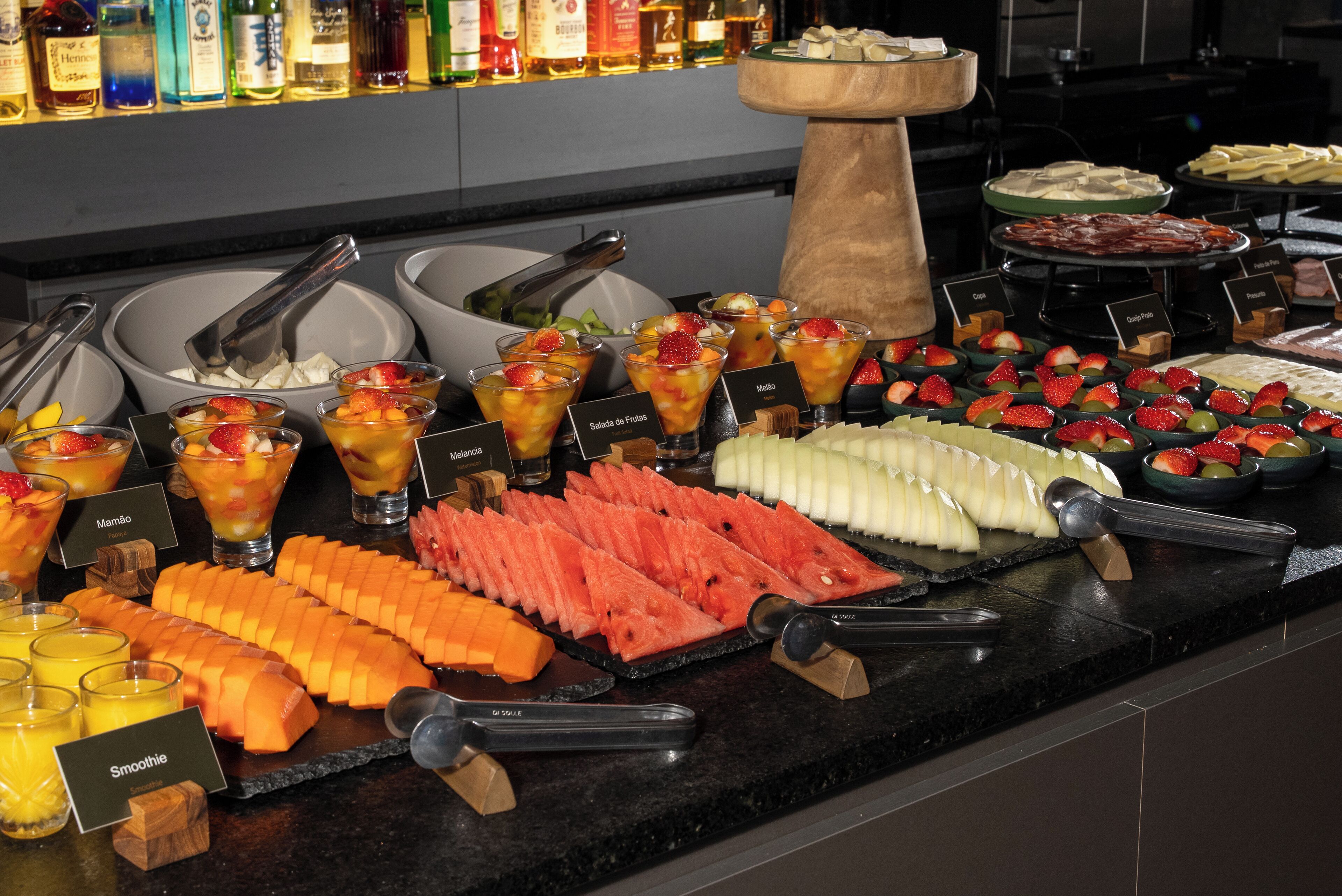 A buffet with various fruit and dessert options, including watermelon, melon, and a selection of cheeses.