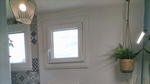A bathroom with a white sink, a towel rack, a hanging plant, a radiator, and patterned tiles. - Quiet house (Bournainville-Faverolles)