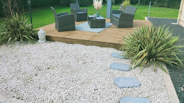 A patio area with wicker furniture, a Buddha statue, and a decorative plant. - Quiet house (Bournainville-Faverolles)