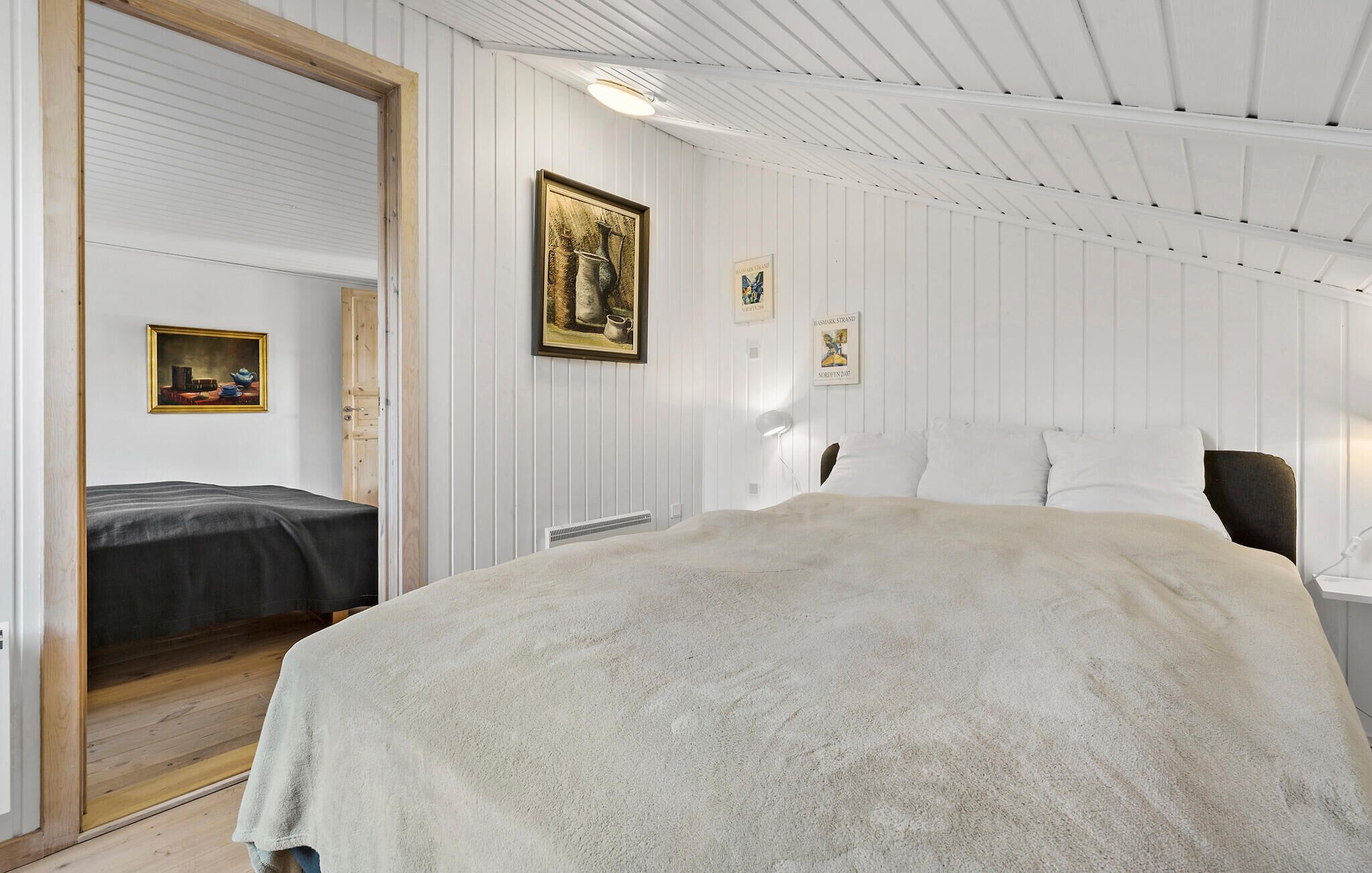 Ein Schlafzimmer mit einem großen Bett, einer Holztür und einer weißen Decke.