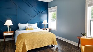 A bedroom with a bed, two bedside tables, a window, and a chair. - Pickwick Places 202 MSU/Rountree (Springfield)