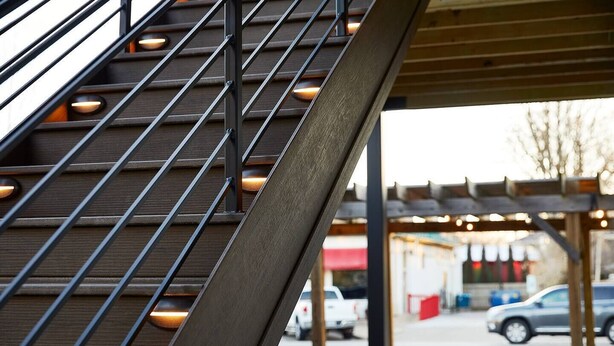 A staircase with metal railings and wooden steps leading to an outdoor area with picnic tables and cars parked nearby. - Pickwick Places 202 MSU/Rountree (Springfield)