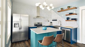 A modern kitchen with a central island, stainless steel appliances, and blue cabinetry. - Pickwick Places 202 MSU/Rountree (Springfield)