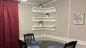 A dining area with a round table, four chairs, and a red curtain. - 3/2 Sunken Treasure Spacious Home in college town of Troy with WiFi, AC (Troy)