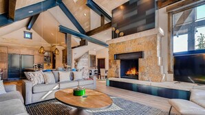 Amplia sala de estar con chimenea, un amplio conjunto de sofás y una mesa de centro.