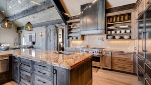 Una cocina moderna con una isla grande, electrodomésticos de acero inoxidable y armarios de madera.