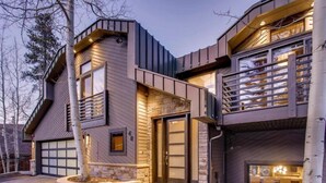 A modern two-story house with a stone facade, large windows, and a garage. - Breck_grand_vista_lodge (Breckenridge)