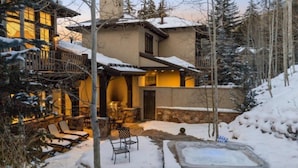 A cozy lodge with a stone patio, outdoor seating, and a hot tub. - Vail_alpenzauber_lodge_5bd (Vail)