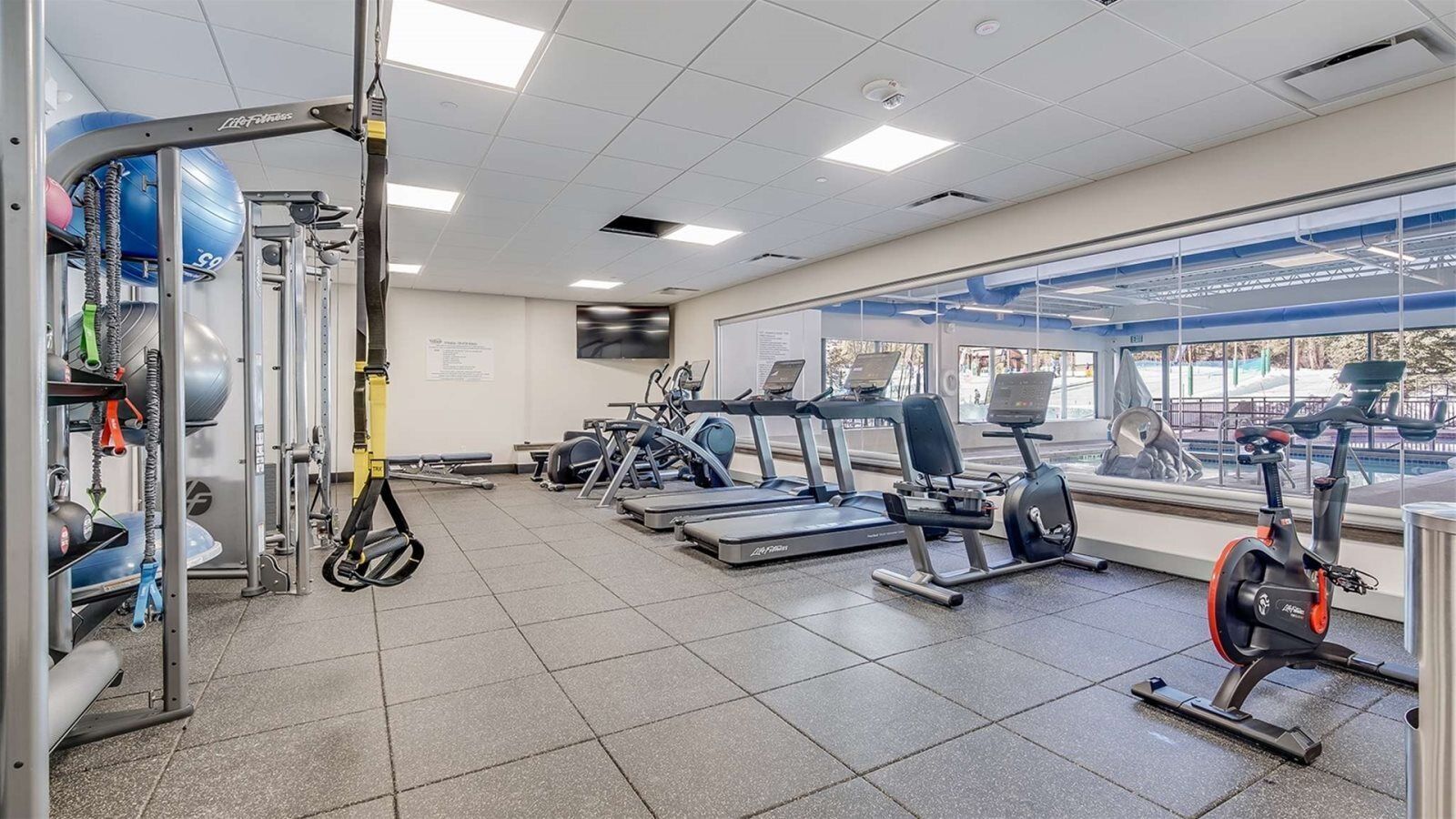 Ett gym med löpband, crosstrainers och utrustning för styrketräning.