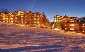 A multi-story lodge with large windows and balconies, situated on a snow-covered slope. - Snowmass_village_3bd_gen_c (Snowmass Village)