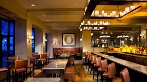 A restaurant with a bar area, booths, and a long counter with bar stools. - Beaver Creek Park Hyatt Double Queen Hotel Room (Avon)