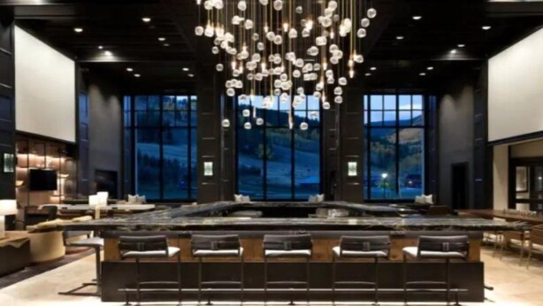 A modern bar area with a long counter and multiple bar stools. - Beaver Creek Park Hyatt Double Queen Hotel Room (Avon)