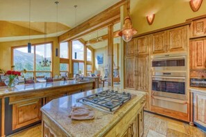 Una cocina amplia con una isla grande, armarios de madera y vistas al exterior.