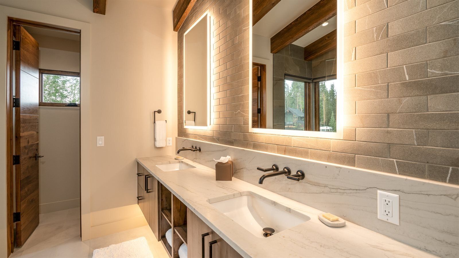 A modern bathroom with two sinks, a large mirror, and a window.
