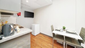 Une cuisine moderne équipée d’une cuisinière intégrée, d’une machine à café et d’un petit réfrigérateur.