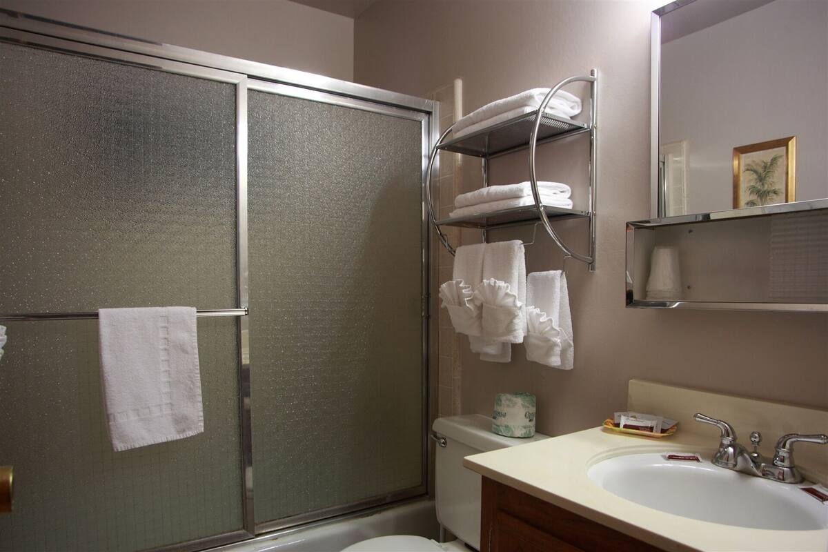 Ein Badezimmer mit Dusche, Toilette, Waschbecken und Handtuchhalter.