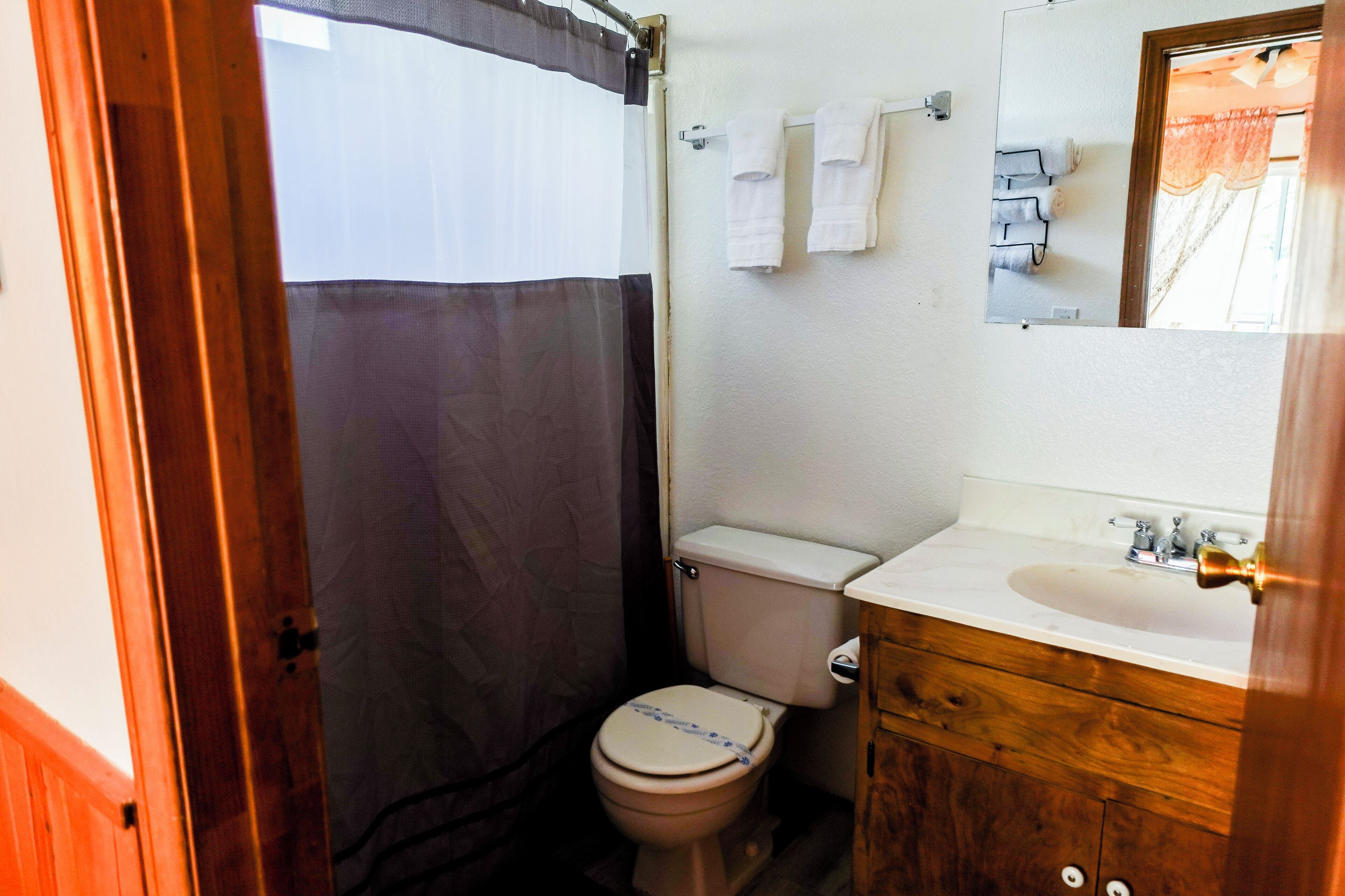 Une petite salle de bain comprenant des toilettes, un lavabo et un miroir.