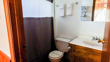 Une petite salle de bain comprenant des toilettes, un lavabo et un miroir.
