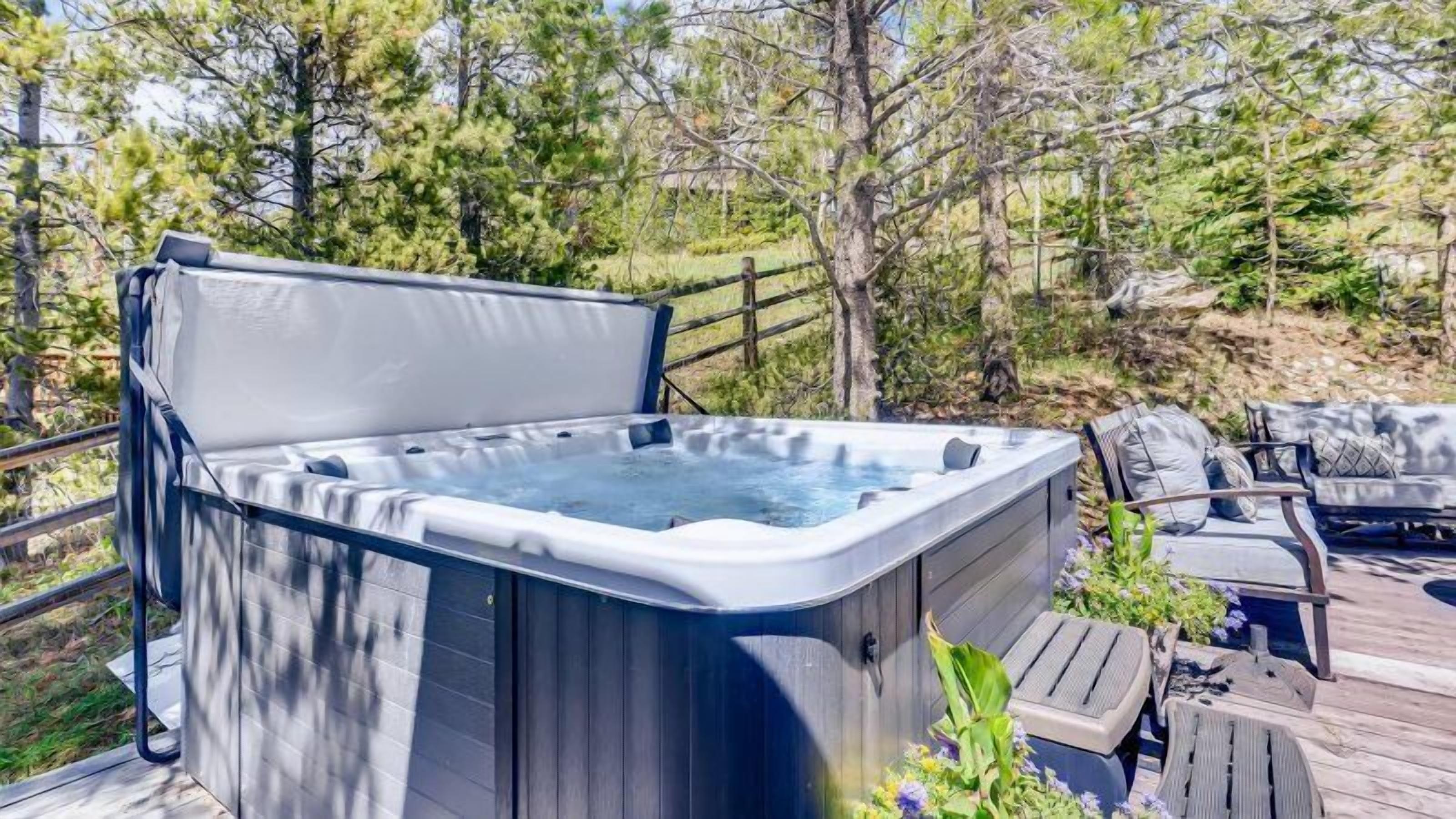 A hot tub on a deck surrounded by trees.