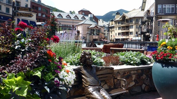 A plaza with a statue, benches, and flower beds. - Beaver_creek_chalet_verve (Avon)