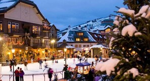 A snow-covered outdoor area with buildings and a clock tower. - Beaver_creek_chalet_verve (Avon)