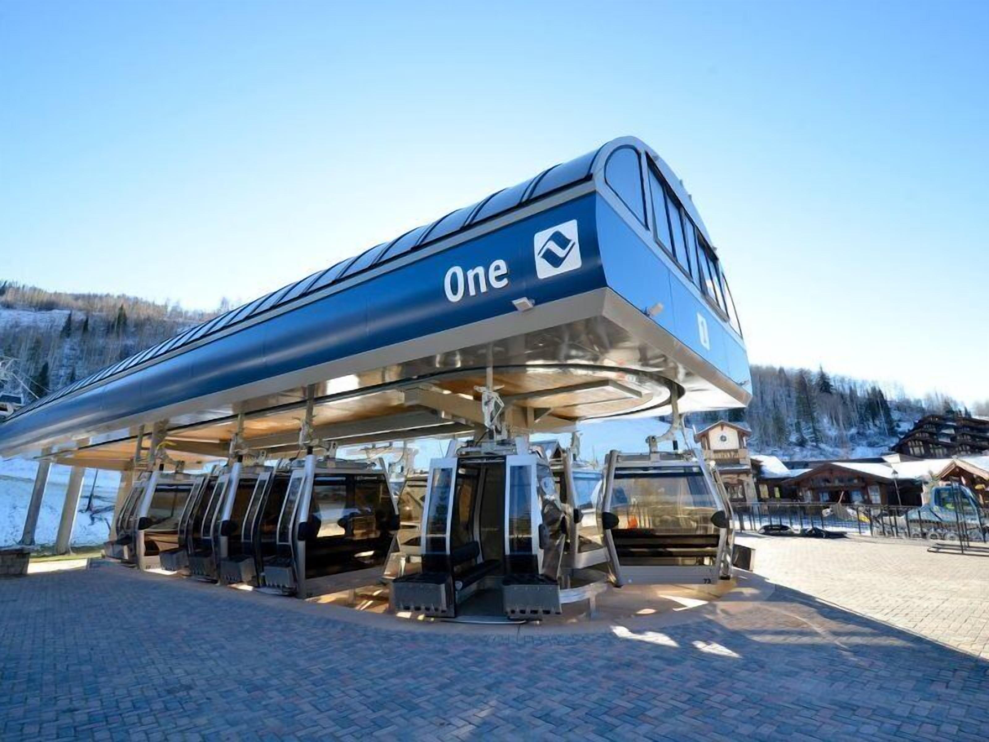 A One ski lift station with a covered waiting area and multiple chairs.