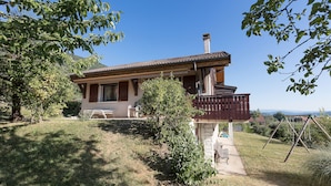 A house with a balcony, a lawn, and a view of the landscape. - SEVRIER, Maison , VUE Panoramique sur le lac et montagnes, 8pers (Sévrier)