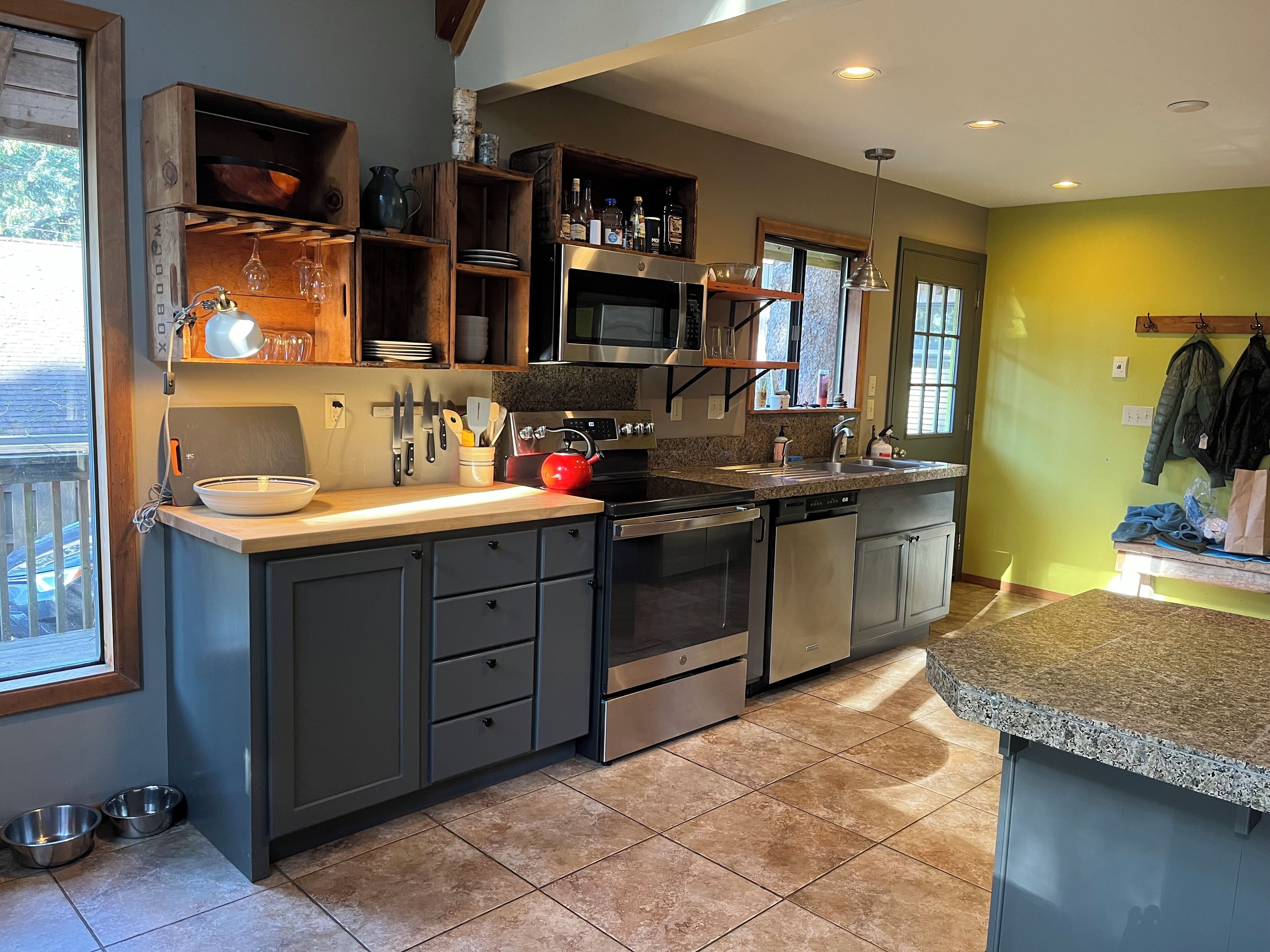 A modern kitchen with dark cabinets, stainless steel appliances, and a granite countertop.