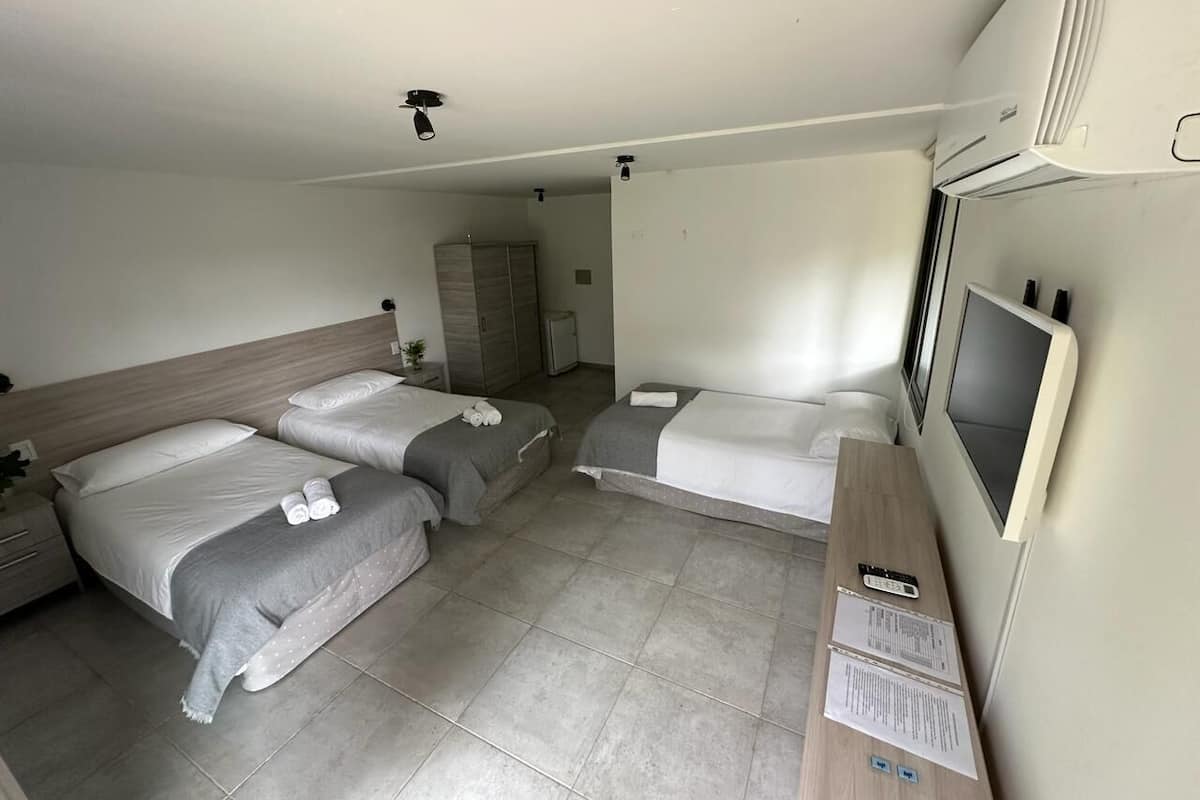 A hotel room with two beds, a TV, a desk, and a wardrobe.