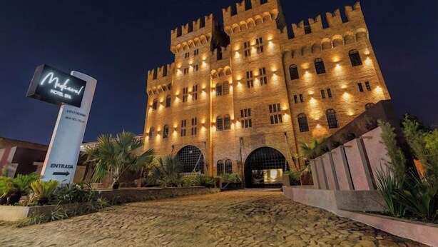 A large, castle-like building with a sign for "Motel Spa" and an entrance sign. - Medieval Motel SPA (Porto Alegre)