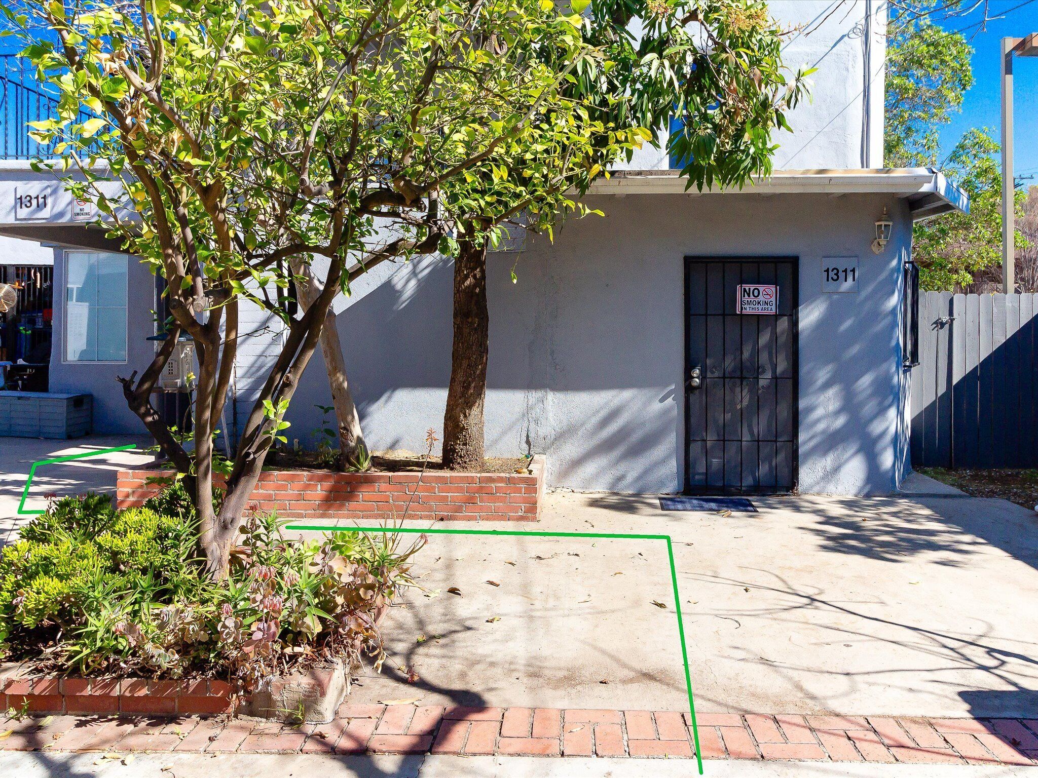 A building with a 'No Smoking' sign, a brick entrance, and a number '1311' on the door.