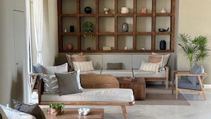 A modern living room with a large wooden bookshelf, a sofa set, and a coffee table.