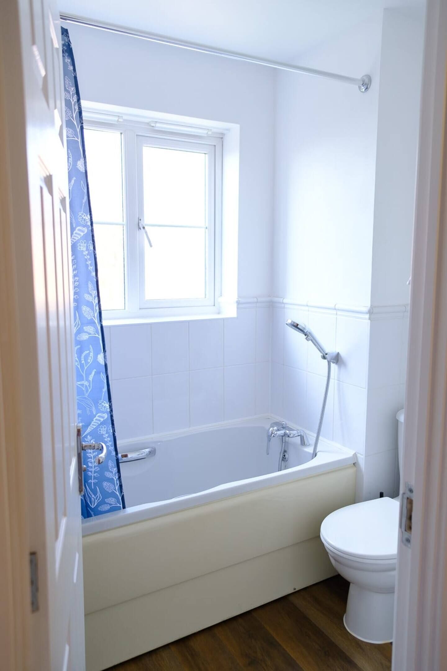 Ein Badezimmer mit einer Badewanne, einer Toilette und einem Fenster.