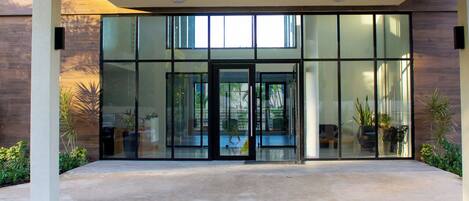 A modern building entrance with glass doors and a concrete walkway.