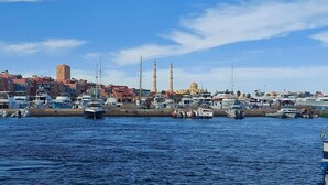 A marina with boats docked, a mosque with two minarets, and a dome in the background. - Florenza Khamsin  , Hurghada (Red Sea Governorate)