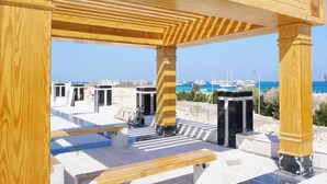 A wooden pergola structure with benches, overlooking a marina with boats and a clear blue sky. - Florenza Khamsin  , Hurghada (Red Sea Governorate)