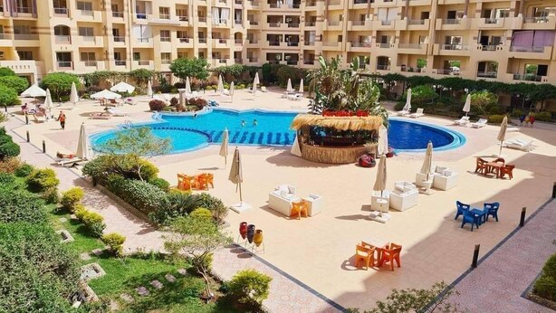 A hotel with multiple floors, a central swimming pool, outdoor seating areas, and a bar. - Florenza Khamsin  , Hurghada (Red Sea Governorate)