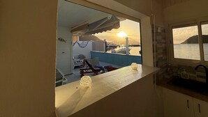 Un balcone con vista su barche e un tramonto.