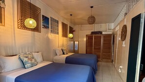 Una camera d'albergo con due letti, un'ampia finestra e un armadio.