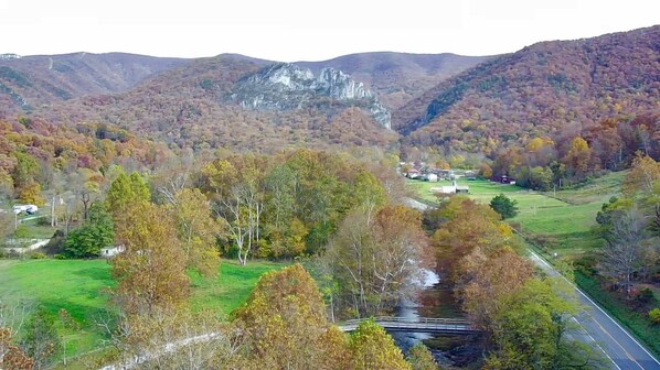 A valley with a river, a bridge, and a small settlement with buildings.