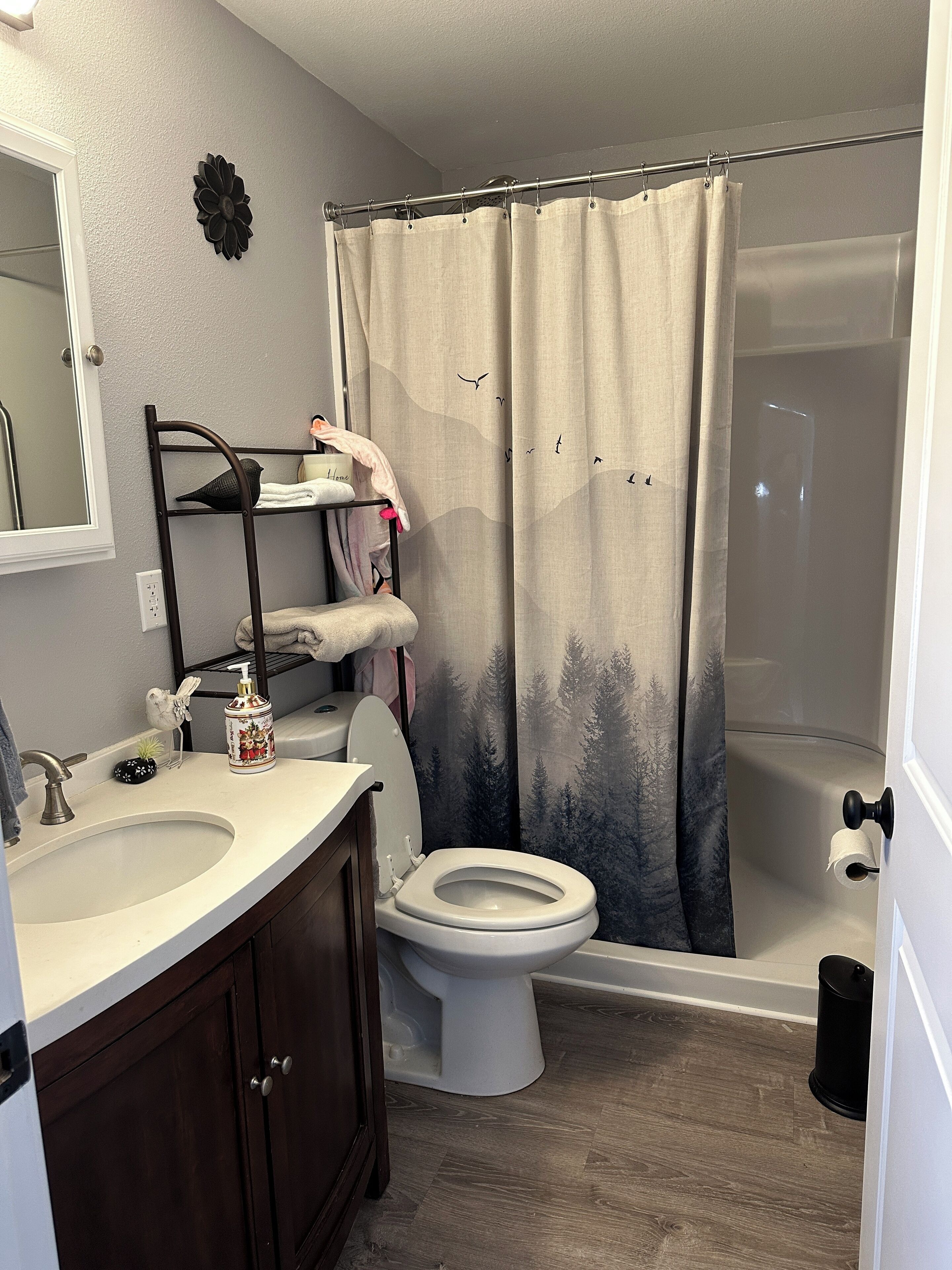 A bathroom with a toilet, sink, and shower curtain.