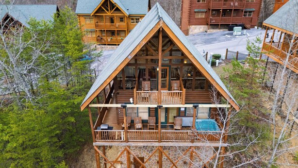 A log cabin with a balcony, a pool, and a view of surrounding cabins. - Anne's Place by Avantstay Cozy Cabin With Hot Tub, Games, Near Dollywood Attractions (Sevierville)