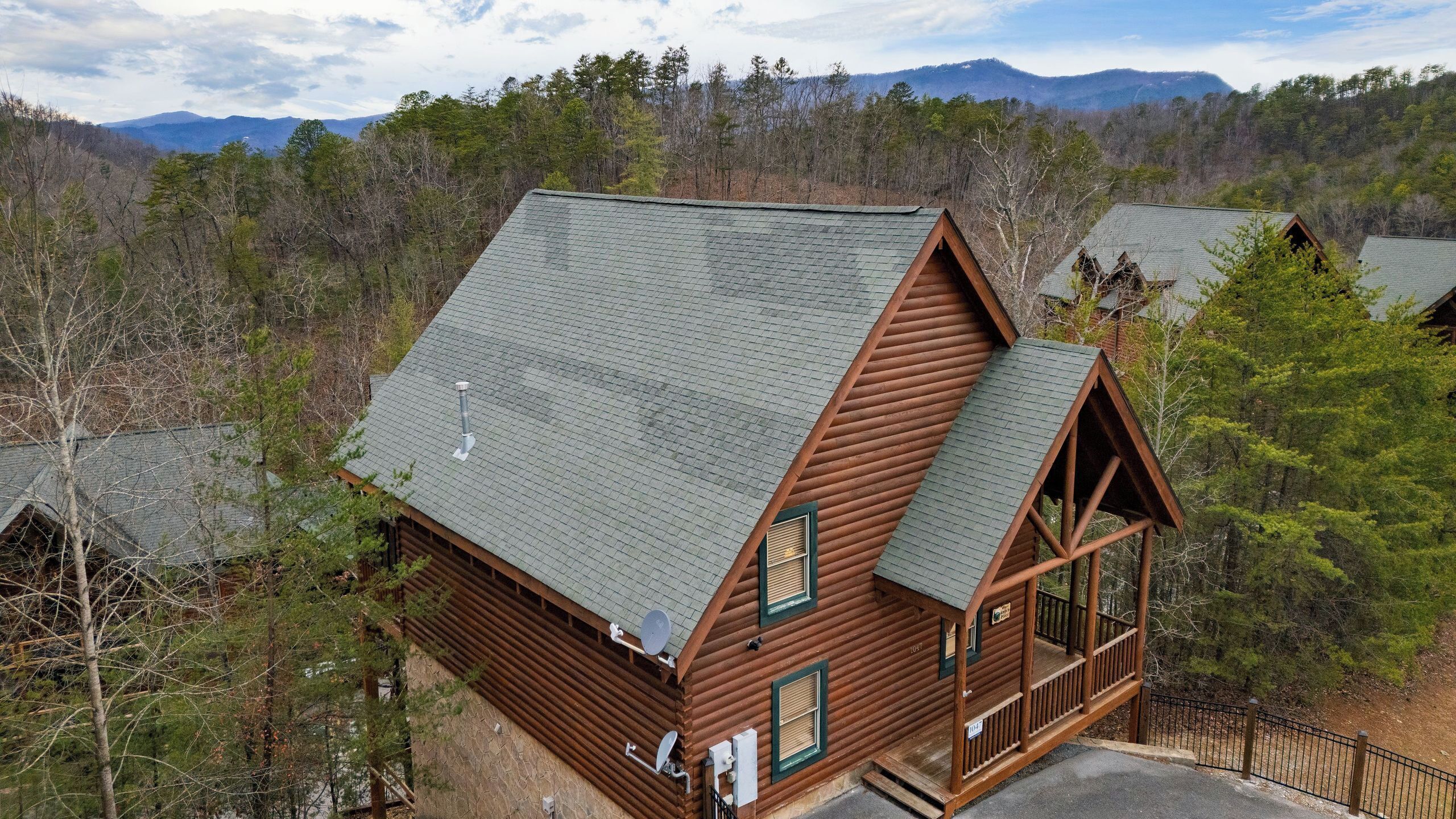 A log cabin with a steep roof, a balcony, and a satellite dish.