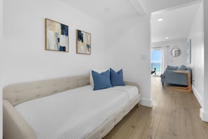 A modern living room with a sofa, a coffee table, and a view of the balcony. - Summit 505 Beach Resort Condo - Balcony Best View (Panama City Beach)