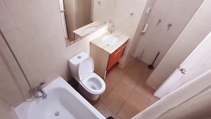 Casa de banho compacta com banheira, sanita e lavatório.