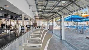 A covered outdoor seating area with chairs and tables, a bar counter, and a view of the outdoor space. - Charming 2-bedroom 1.5 Bath Cottage in the famous Sun Outdoors in Sarasota (Sarasota)