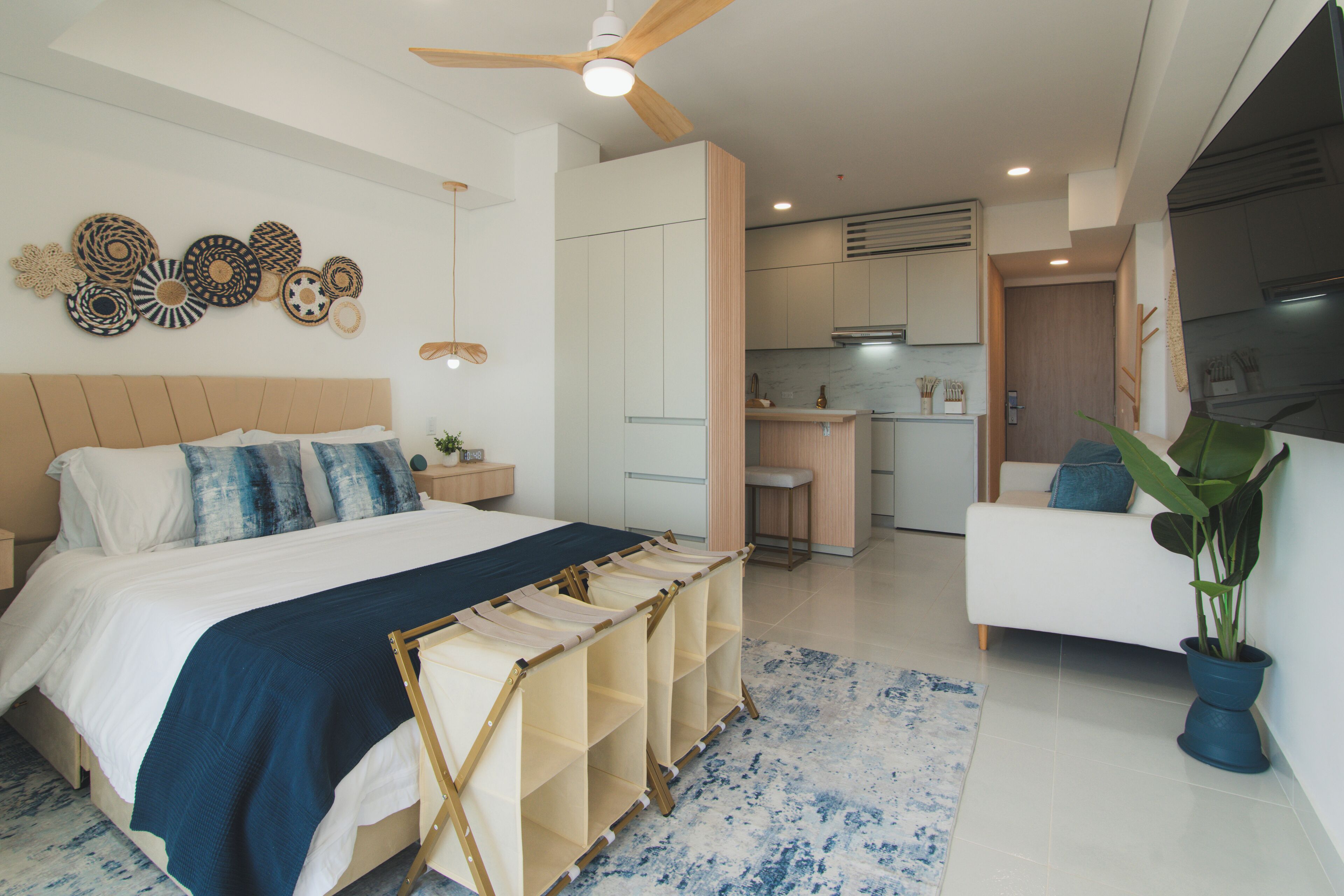 Un dormitorio moderno con una cama grande, un escritorio y una kitchenette.