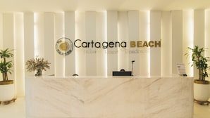 Un mostrador de recepción en Cartagena Beach con encimera de mármol, un logotipo y un letrero que indica que es una residencia exclusiva.