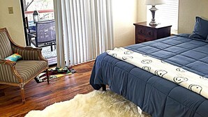 A bedroom with a bed, a chair, a lamp, and a fur rug. - Relax with the whole family or group of friends at this cozy Behr Hideout! (Alto)